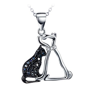 Silberkette mit einem Anhänger mit einer schwarzen Zirkoniakatze neben einem Hund mit einem kleinen weißen Zirkonia Halsband.